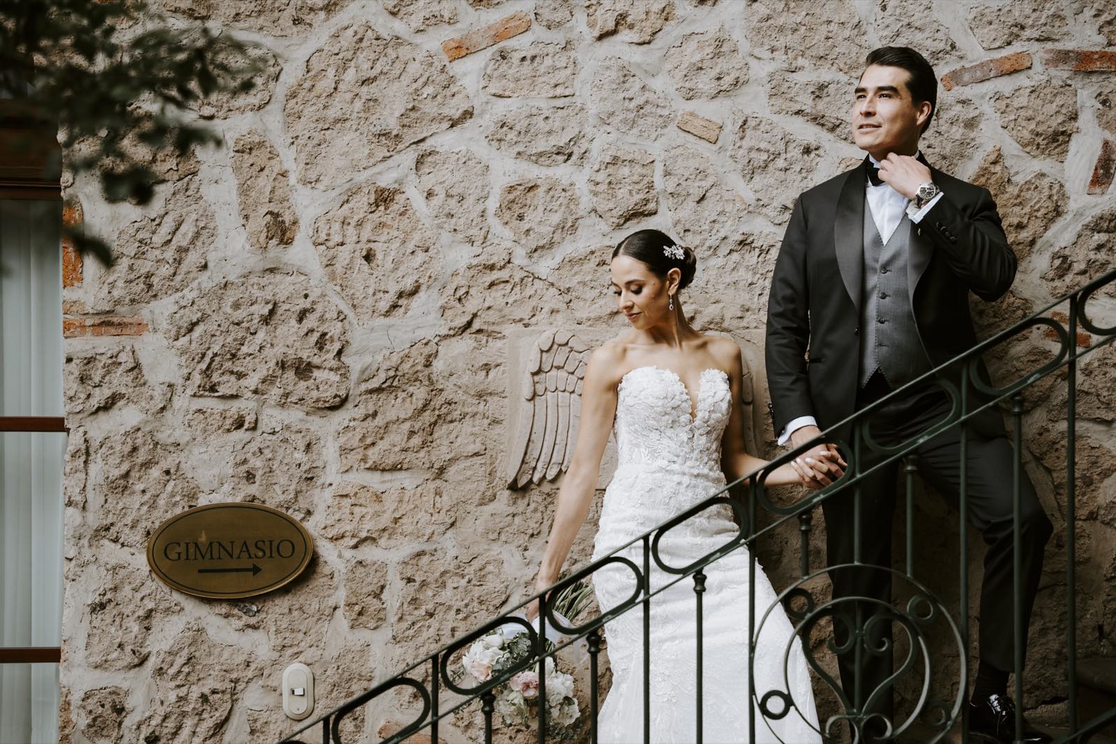 Los novios en una escalera junto a un muro de piedra